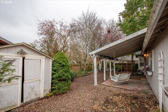 view of yard featuring a patio and a shed