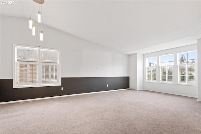 carpeted empty room with high vaulted ceiling