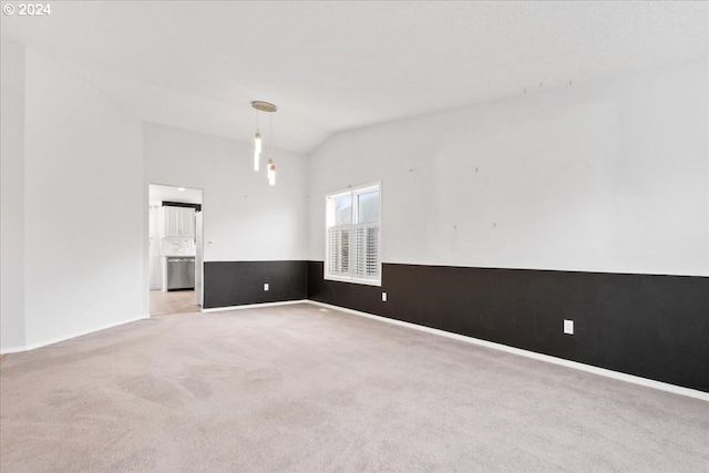 unfurnished room featuring light colored carpet and vaulted ceiling