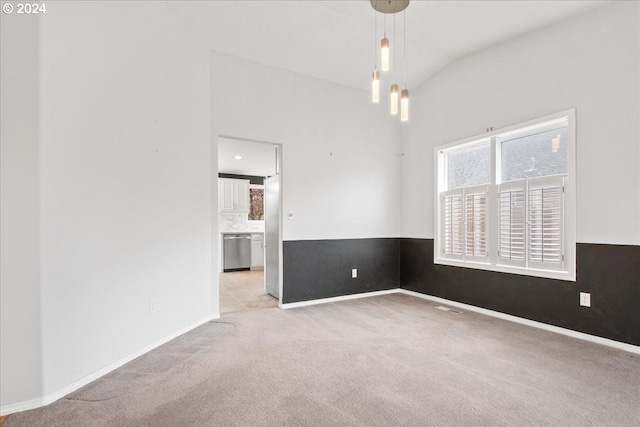 spare room featuring light colored carpet and vaulted ceiling