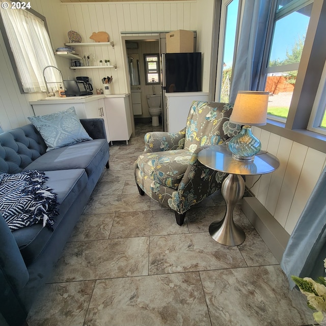 living room featuring a healthy amount of sunlight and wooden walls