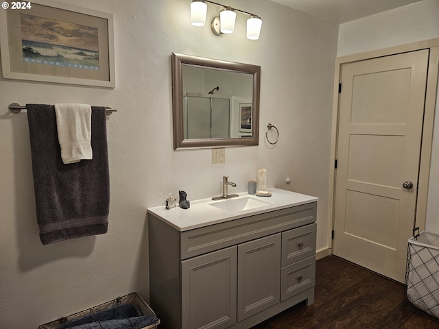 bathroom featuring a shower with door, vanity, and hardwood / wood-style flooring