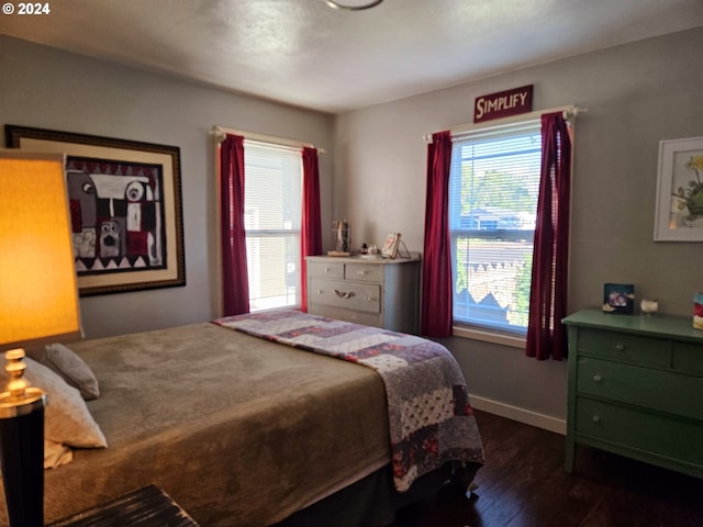 bedroom featuring dark wood-type flooring and multiple windows