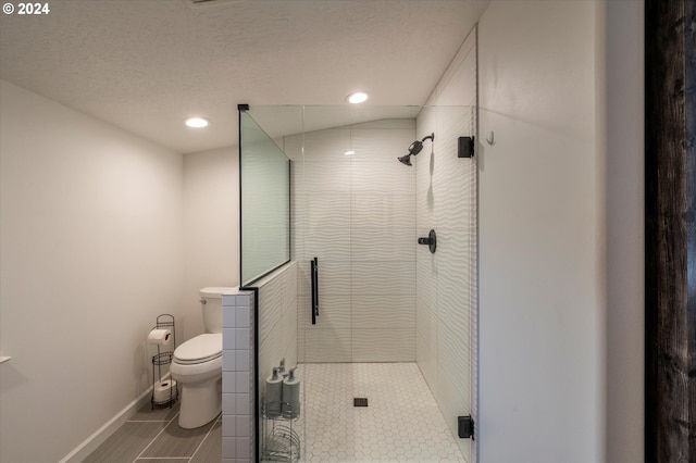 bathroom with recessed lighting, toilet, a stall shower, a textured ceiling, and baseboards