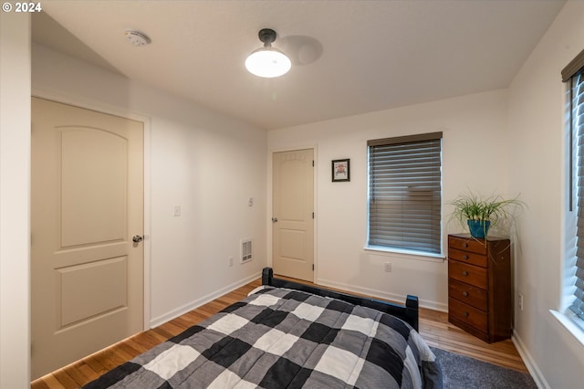 bedroom featuring visible vents, baseboards, and wood finished floors