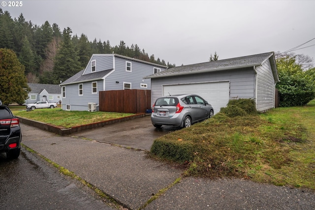 view of home's exterior with a garage, a yard, and driveway