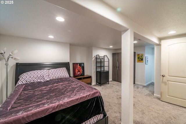 bedroom featuring recessed lighting, light colored carpet, a textured ceiling, and baseboards