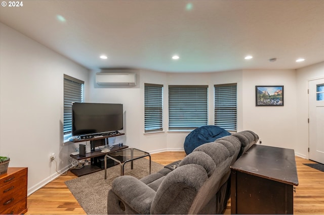 living room featuring recessed lighting, an AC wall unit, baseboards, and light wood finished floors