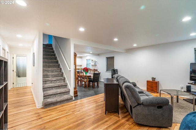 living area featuring recessed lighting, light wood finished floors, and stairs