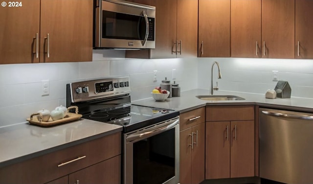 kitchen featuring sink, appliances with stainless steel finishes, and decorative backsplash