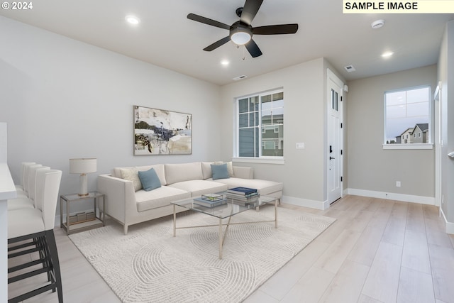 living room with light hardwood / wood-style floors and ceiling fan