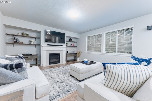 living room with wood-type flooring and a textured ceiling