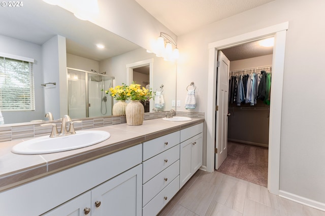 bathroom featuring tile patterned flooring, vanity, and walk in shower