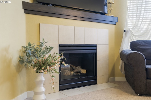 interior details with a tiled fireplace and carpet floors