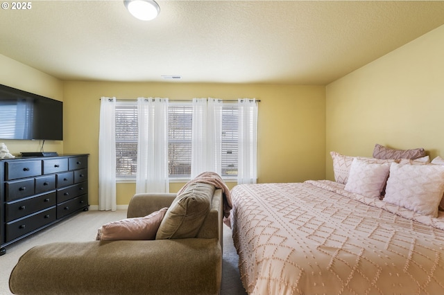 bedroom with light carpet and a textured ceiling