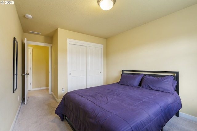 bedroom with light colored carpet and a closet