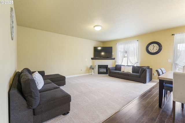 living room featuring a tile fireplace, hardwood / wood-style floors, and a textured ceiling