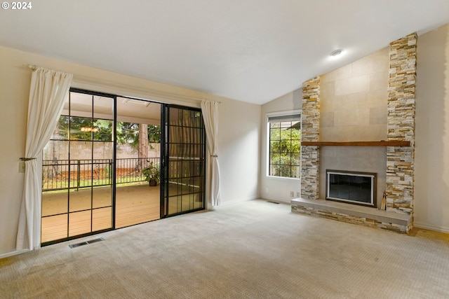 unfurnished living room featuring a wealth of natural light, a fireplace, and carpet