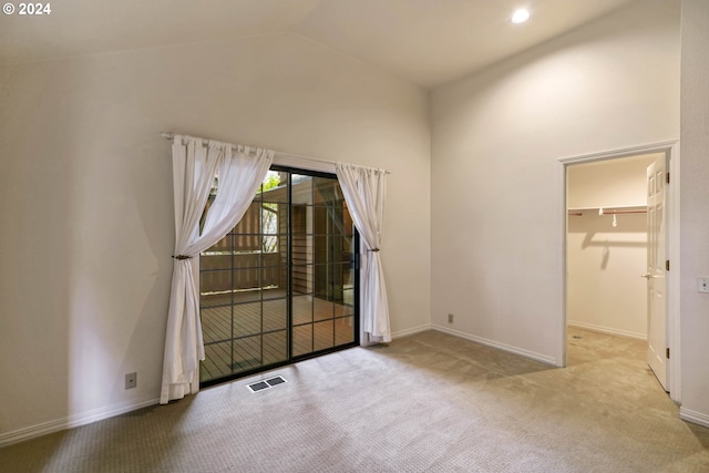 carpeted empty room with lofted ceiling