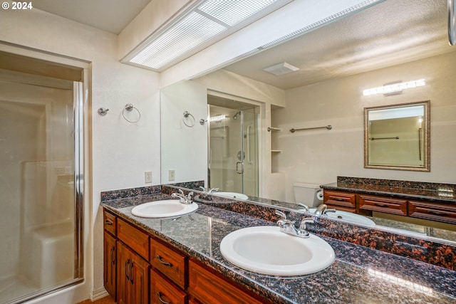 bathroom featuring vanity, toilet, and a shower with shower door