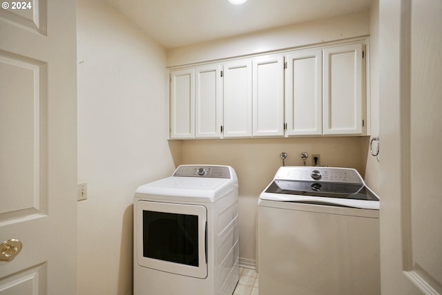 laundry area with cabinets, independent washer and dryer, and light tile patterned floors