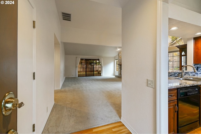 hallway with light carpet and sink