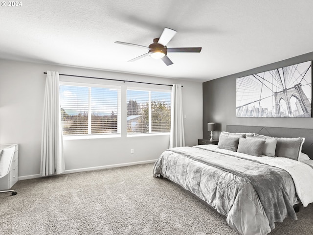 bedroom featuring multiple windows, a textured ceiling, ceiling fan, and carpet floors