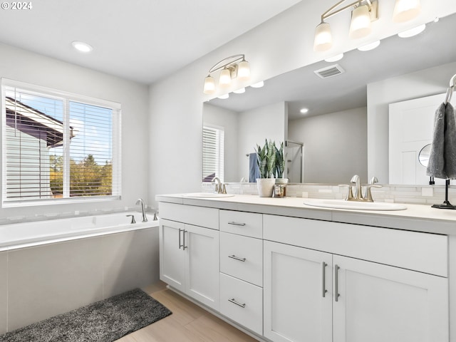 bathroom featuring hardwood / wood-style floors, vanity, and a washtub