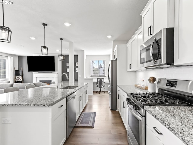 kitchen featuring appliances with stainless steel finishes, sink, white cabinetry, and a wealth of natural light