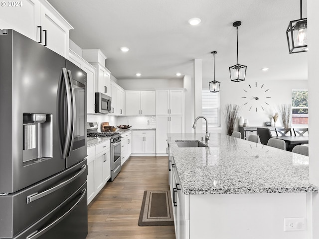 kitchen featuring a kitchen island with sink, stainless steel appliances, plenty of natural light, and sink