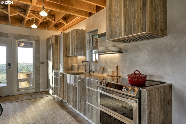 kitchen featuring stainless steel range with electric stovetop, sink, and beamed ceiling