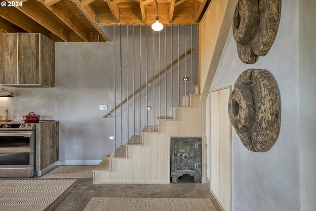 staircase featuring a high ceiling and wood walls