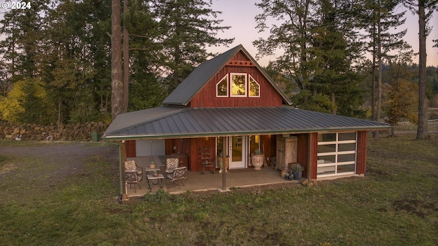 6850 SE Eola Hills Rd, Amity, OR 97101 - back of house at dusk with a yard, metal roof, a patio, and french doors