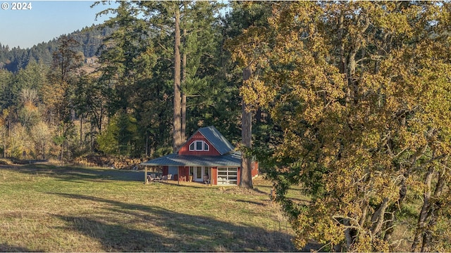 6850 SE Eola Hills Rd, Amity, OR 97101 - view of property exterior featuring a view of trees, a lawn, and metal roof