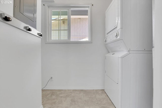 clothes washing area featuring stacked washer and dryer