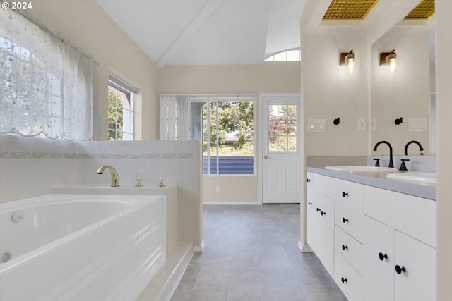 bathroom with vanity, lofted ceiling, and a tub to relax in