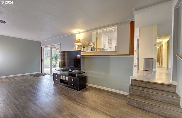 living room with a textured ceiling and hardwood / wood-style floors