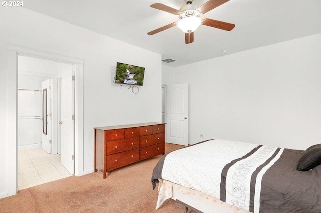 carpeted bedroom with ensuite bathroom and ceiling fan