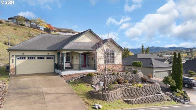 view of front facade with a mountain view, a garage, and covered porch