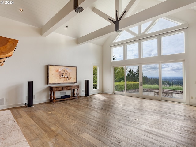 unfurnished living room featuring high vaulted ceiling, beam ceiling, and light hardwood / wood-style floors