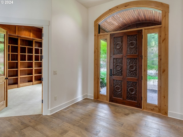 entrance foyer with vaulted ceiling, wooden ceiling, and light hardwood / wood-style flooring