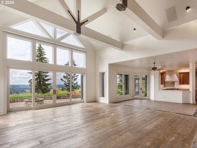 unfurnished living room featuring a healthy amount of sunlight and high vaulted ceiling