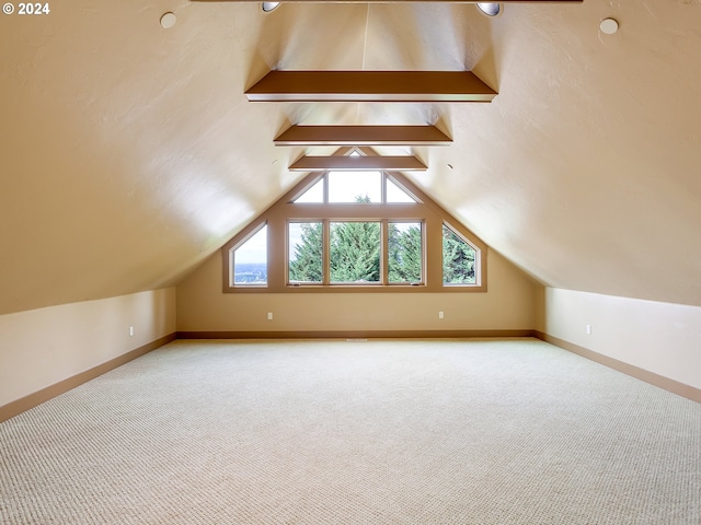 bonus room featuring carpet floors and lofted ceiling with beams