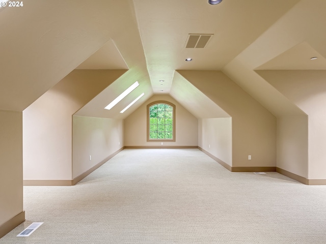 bonus room featuring light colored carpet and lofted ceiling with skylight