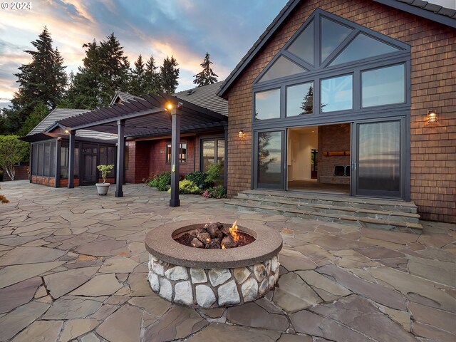 back house at dusk with a patio and a fire pit