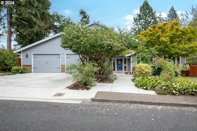 view of property hidden behind natural elements featuring a garage