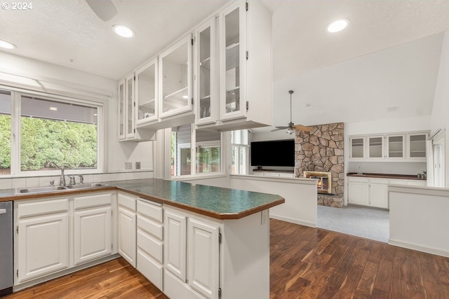 kitchen with kitchen peninsula, white cabinetry, sink, and plenty of natural light