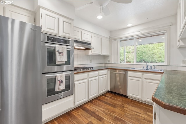 kitchen with white cabinets, stainless steel appliances, and dark wood-type flooring