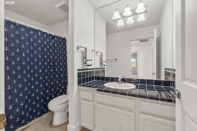 bathroom with a shower with shower curtain, vanity, wood-type flooring, and toilet