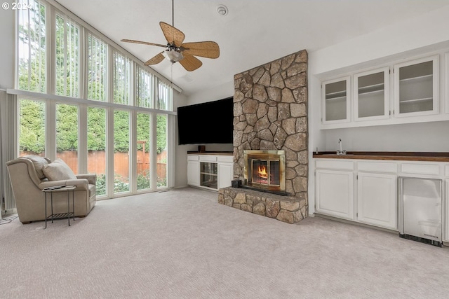 carpeted living room with ceiling fan, sink, a fireplace, and high vaulted ceiling